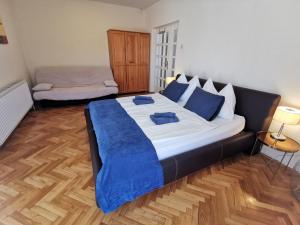a bedroom with a large bed with a blue blanket at Kovács Apartmanház in Balatonfüred +68 photos