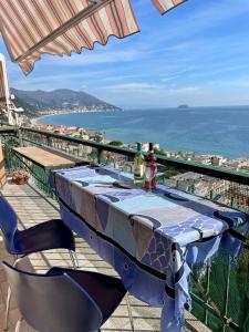 a table on a balcony with a view of the ocean at Orizzonte guest house in Laigueglia