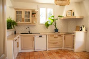a kitchen with white cabinets and a sink at Casa Mamou in Cavaillon