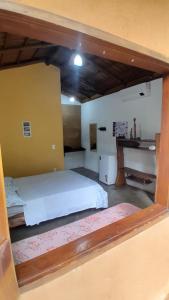 ein Schlafzimmer mit einem großen weißen Bett und einem Schreibtisch in der Unterkunft Chalés Santo Verde 2 in Goiás
