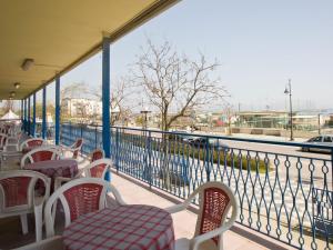 a balcony with tables and chairs and a view of a street at Hotel Moja in Cesenatico