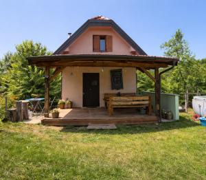 a small house with a large wooden deck at Glamping Volčji tabor - zavetje tišine sredi gozda in Gornja Voća