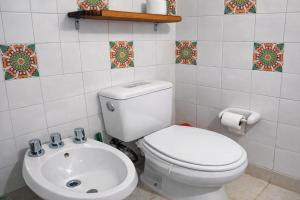 a bathroom with a white toilet and a sink at Cabañas Tunquelen in El Bolsón +20 photos