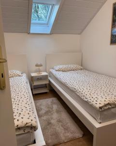 two beds in a small room with a window at Ferienhaus Eiforia in Gerolstein