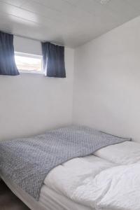 a white bed with blue curtains in a bedroom at Sigtun 55 in Patreksfjörður +13 photos