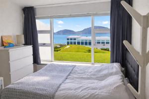 a bedroom with a bed and a large window at Sigtun 55 in Patreksfjörður