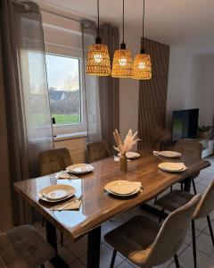 a dining room table with chairs and chandeliers at Ferienhaus Eiforia in Gerolstein