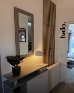 a bathroom with a vanity with a mirror and a plant at Ferienhaus Eiforia in Gerolstein +28 photos