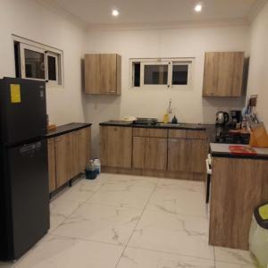 a kitchen with wooden cabinets and a black refrigerator at Dushi Boca Sami in Dorp Sint Michiel +11 photos