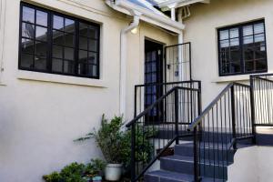 a white house with a staircase and windows at Hilton Heath in Hilton