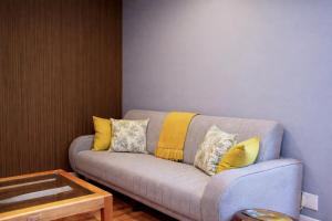 a gray couch with yellow pillows in a living room at Hilton Heath in Hilton