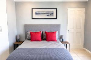 a bedroom with a bed with red pillows at Hilton Heath in Hilton