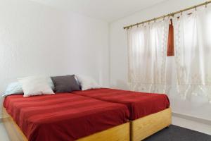 uma cama num quarto branco com um cobertor vermelho em For You Rentals Alfonso XIII Apartment em Madri