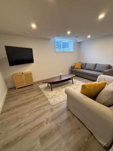 a living room with a couch and a tv at Hidden Gem in Airdrie