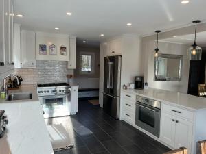 a kitchen with white cabinets and a black refrigerator at Mill Lane in Stowe +36 photos