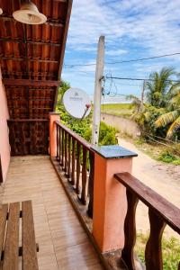 a porch with a bench and a view of a field at Pousada Casarão Piúma in Piúma