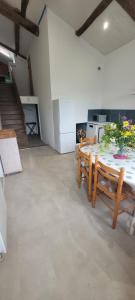 a room with a table and chairs and a staircase at rêve d'escapade in Mouilleron-en-Pareds