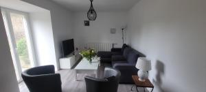 a living room with a couch and a tv at rêve d'escapade in Mouilleron-en-Pareds