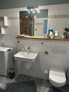 a bathroom with a sink and a toilet and a mirror at Die kleine Acht - direkt am Strand in Dierhagen +43 photos