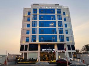 a building with a car parked in a parking lot at فندق ليان بارك Lian Park Hotel in Al Khobar