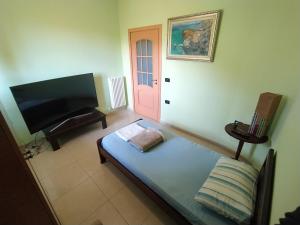 a living room with a bed and a flat screen tv at Pinwheel Hostel Vlora & Rooftop Bar in Vlorë