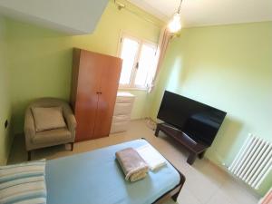 a bedroom with a bed and a tv and a chair at Pinwheel Hostel Vlora & Rooftop Bar in Vlorë +44 photos