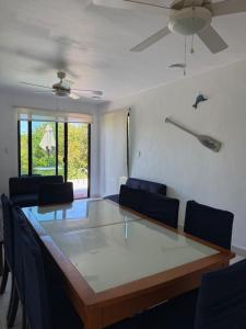 a dining room table with chairs and a ceiling fan at Casa Nora in Sisal