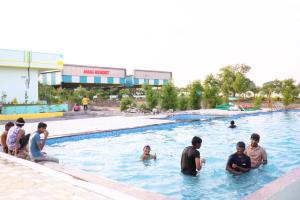 a group of people in a swimming pool at MMG Resorts in Nāspur