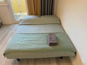 a bed with a green blanket and a towel on it at Ostoja Apartament Bytom Miechowice 24H - blisko A1, Gliwice 15 min in Bytom
