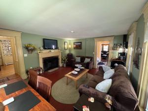 a living room with a couch and a fireplace at Ballard House Inn in Meredith