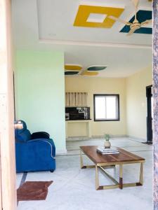 a living room with a blue couch and a coffee table at MMG Resorts in Nāspur