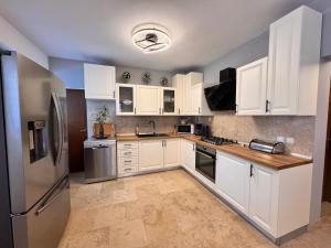 a kitchen with white cabinets and stainless steel appliances at Apartment olive tree garden&poll view 4 plus 2, 130 m2 with tiki bar in Peroj