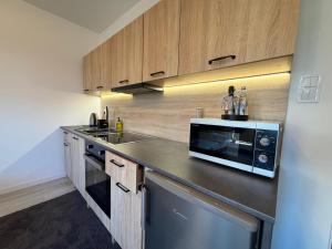 a kitchen with a sink and a microwave at Ostoja Apartament Bytom Miechowice 24H - blisko A1, Gliwice 15 min in Bytom