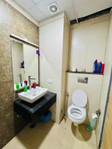 a bathroom with a toilet and a sink at The Skyline Studios in Ghaziabad