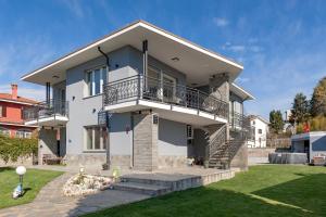 a white house with a balcony and a yard at Lore Sole in Caluso