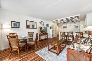 a living room with a couch and a table and chairs at Kona Pacific E629: Beautifully Remodeled condo! in Kailua-Kona