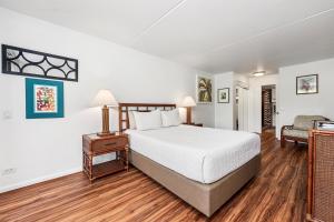 a bedroom with a bed and a desk and a chair at Kona Pacific E629: Beautifully Remodeled condo! in Kailua-Kona +28 photos