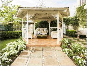 a white gazebo with chairs and a bench at De Ark Guest House in Lydenburg