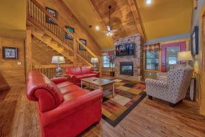 a living room with red furniture and a staircase at Break Time in Gatlinburg