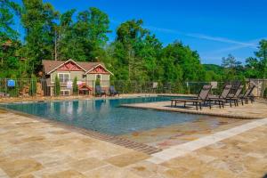 a swimming pool with chairs and a house at Break Time in Gatlinburg
