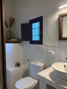a bathroom with a toilet and a sink and a window at Finca Los Arcos Bed and Breakfast Comares Malaga in Comares +27 photos