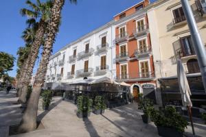 a street in front of a building with palm trees at Bari LandLord 71 - Private Balcony Suites in Bari