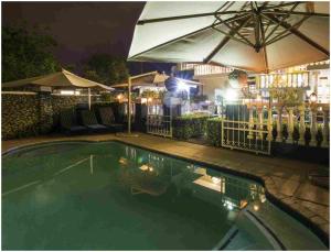 a swimming pool at night with an umbrella at De Ark Guest House in Lydenburg