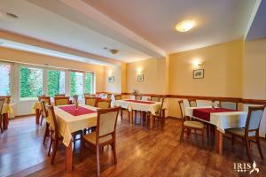 a restaurant with tables and chairs in a room at Pensiunea Iris in Băile Tuşnad