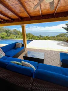 a living room with blue couches on a patio at Ballena Bay Villa Lot 45 Villa del Mar in Tambor