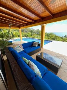 a patio with blue couches and a swimming pool at Ballena Bay Villa Lot 45 Villa del Mar in Tambor
