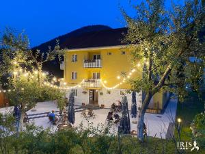 a yellow building with lights in a courtyard at night at Pensiunea Iris in Băile Tuşnad