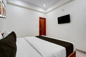 a bedroom with a bed and a television on the wall at Hotel O rudra paradise in New Delhi