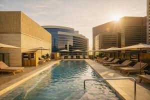 a hotel pool with lounge chairs and umbrellas at Denu Hotel & Spa in Phoenix