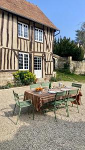 a table and chairs in front of a house at Le Clos des Grands Jardins in Giverny